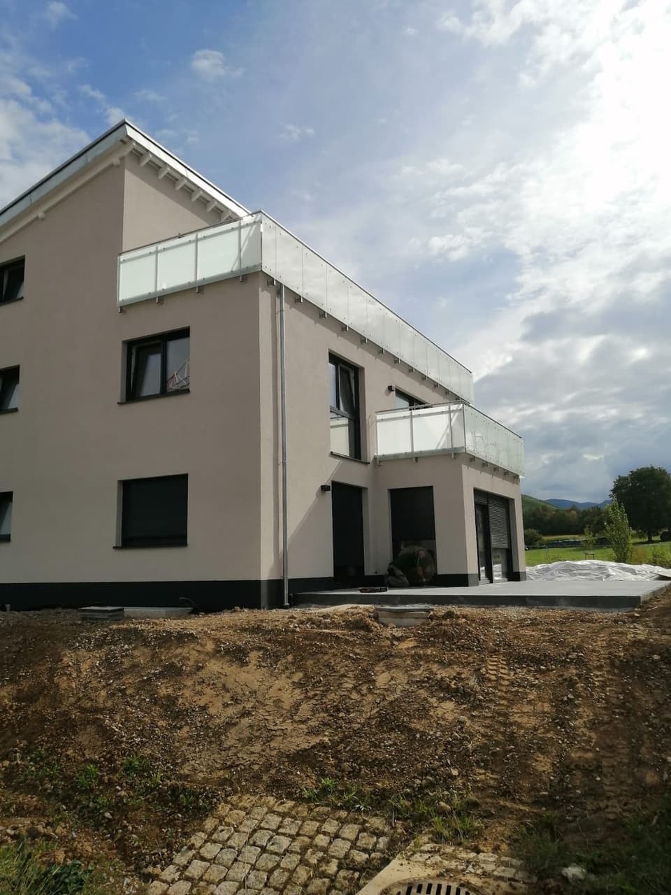 Neubau mit Balkongelaender aus Glas und Metall – Luft Metallbau